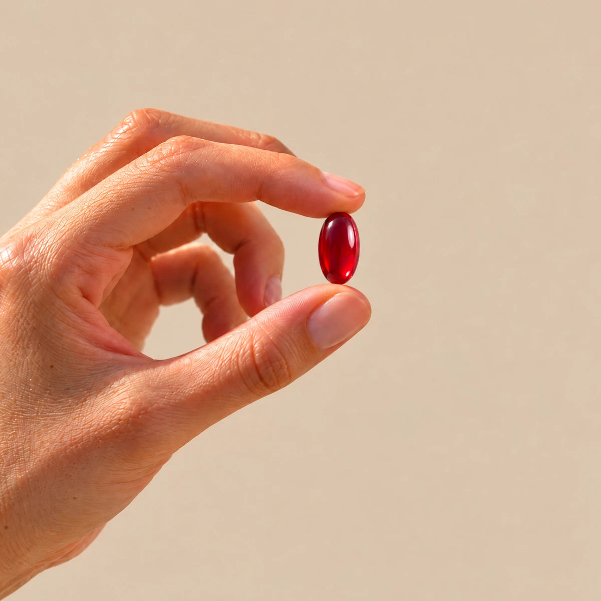 perla di Omega 3 Krill Oil tenuta tra le dita