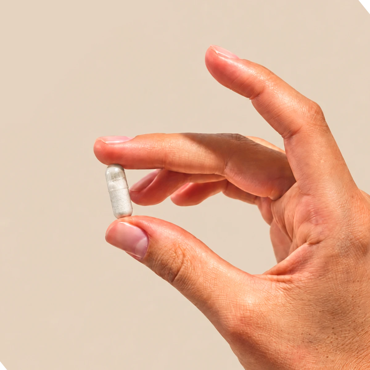 capsula di DKE + Magnesio tenuta tra le dita